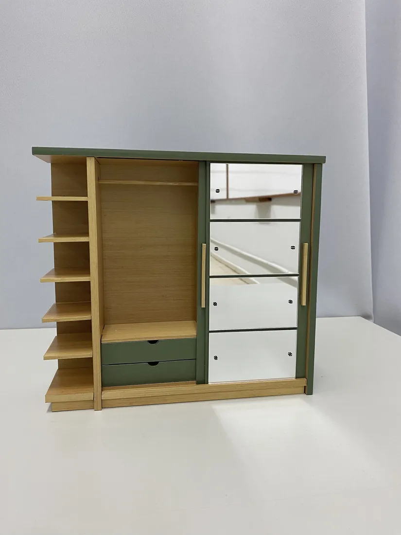 Maquete com a porta verde deslizada para o lado, mostrando o cabideiro e duas gavetas.