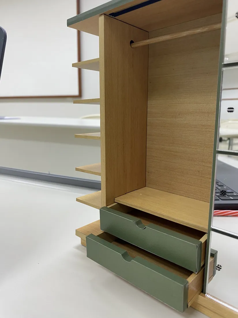 Lateral da maquete com as duas gavetas verdes puxadas para fora.